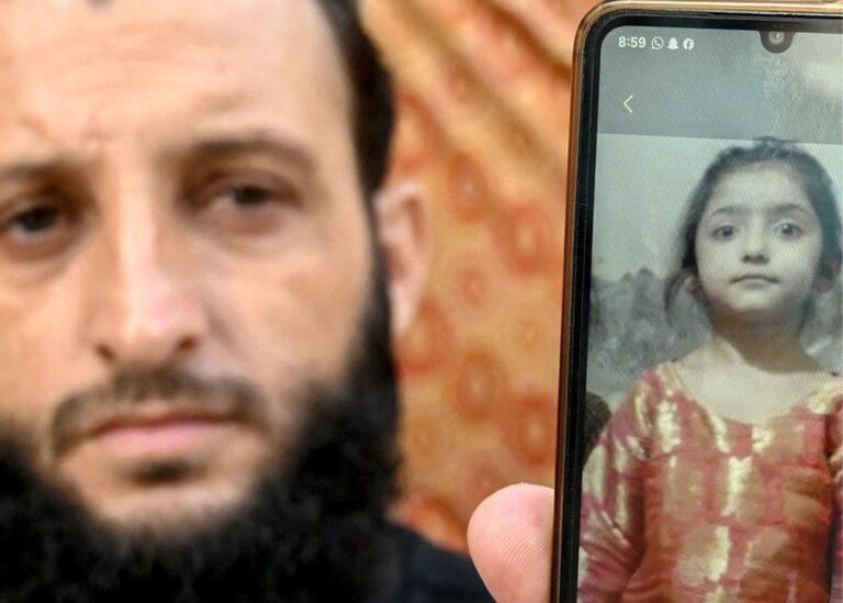 پشاور میں اسکول کے حادثے سے متاثرہ خاندان کا فرد موبائل پر تصویر دکھاتے ہوئے