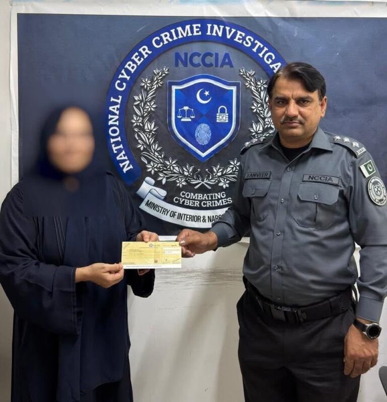 این سی سی آئی اے کا افسر ایک خاتون کو ریکور کی گئی رقم کا چیک پیش کر رہا ہے