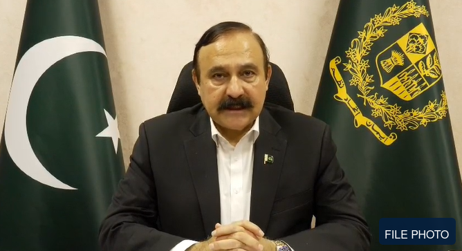 فائل فوٹو — پاکستان کے پرچم اور سرکاری نشان کے سامنے کھڑے ایک سیاسی شخصیت کی فائل فوٹو
