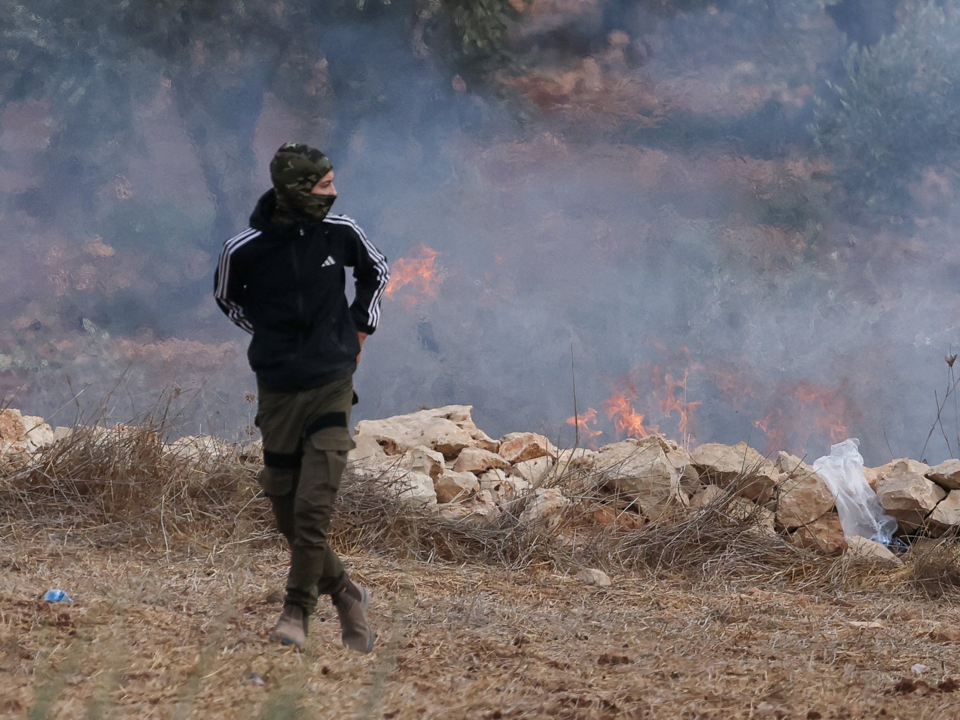 فائل فوٹو — فلسطین میں کشیدگی اور دھویں کے پس منظر میں ایک شخص کی تصویر